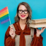 Young woman with books and LGBT flag