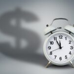Alarm clock with dollar shadow, time is money concept