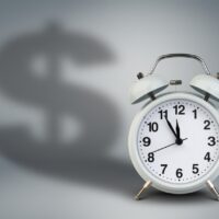 Alarm clock with dollar shadow, time is money concept