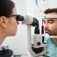 optician with tonometer and patient at eye clinic