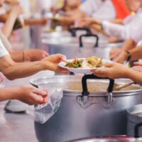 Sharing of food from volunteer hands to homeless people : The co Sharing of food from volunteer hands to homeless people : The co