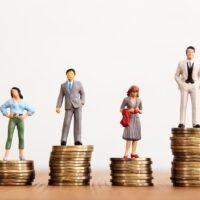 Conceptual image of gender inequality. A women and a men with income difference Conceptual image of gender inequality. A women and a men with income difference