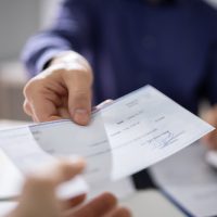 business owner giving pay to employee business owner giving pay to employee