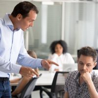 Angry boss is scolding frustrated incompetent employee