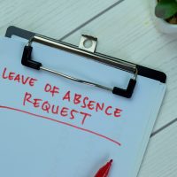 Concept of Leave of Absence Request write on paperwork isolated on Wooden Table. Concept of Leave of Absence Request write on paperwork isolated on Wooden Table.