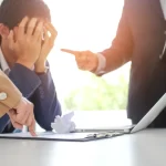 Angry boss Bullying with an out of control boss shouting to a stressed employee. Anger issues and stress office bullies concept