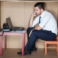 depressed businessman in a cardboard office